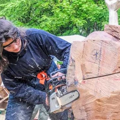 Angehende Holzbildhauerin bearbeitet Skulpturrohling