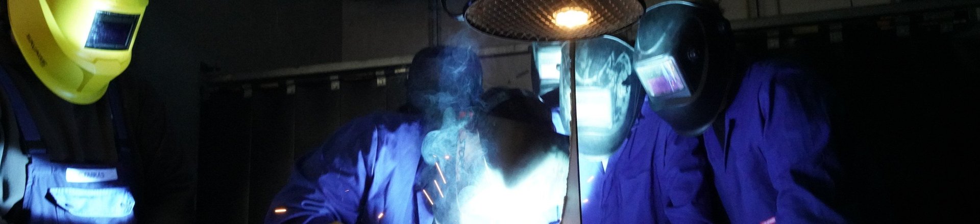 Schüler schweißen ein Werkstück in der Schweißwerkstatt