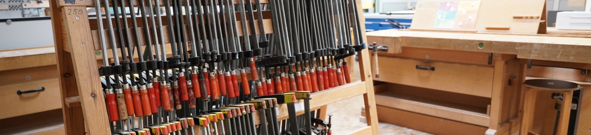 Blick in die Holzwerkstatt auf ein Ständer mit Schraubzwingen